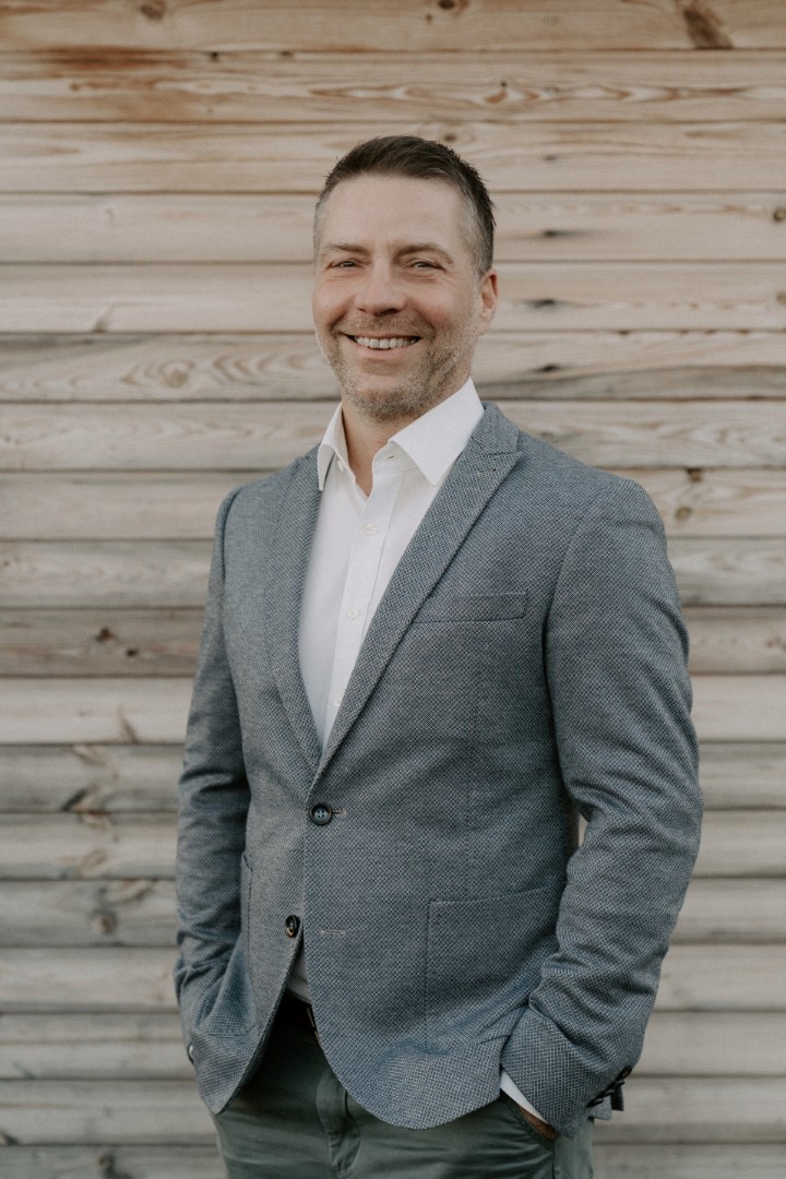Michael Becker vor einer Holzwand